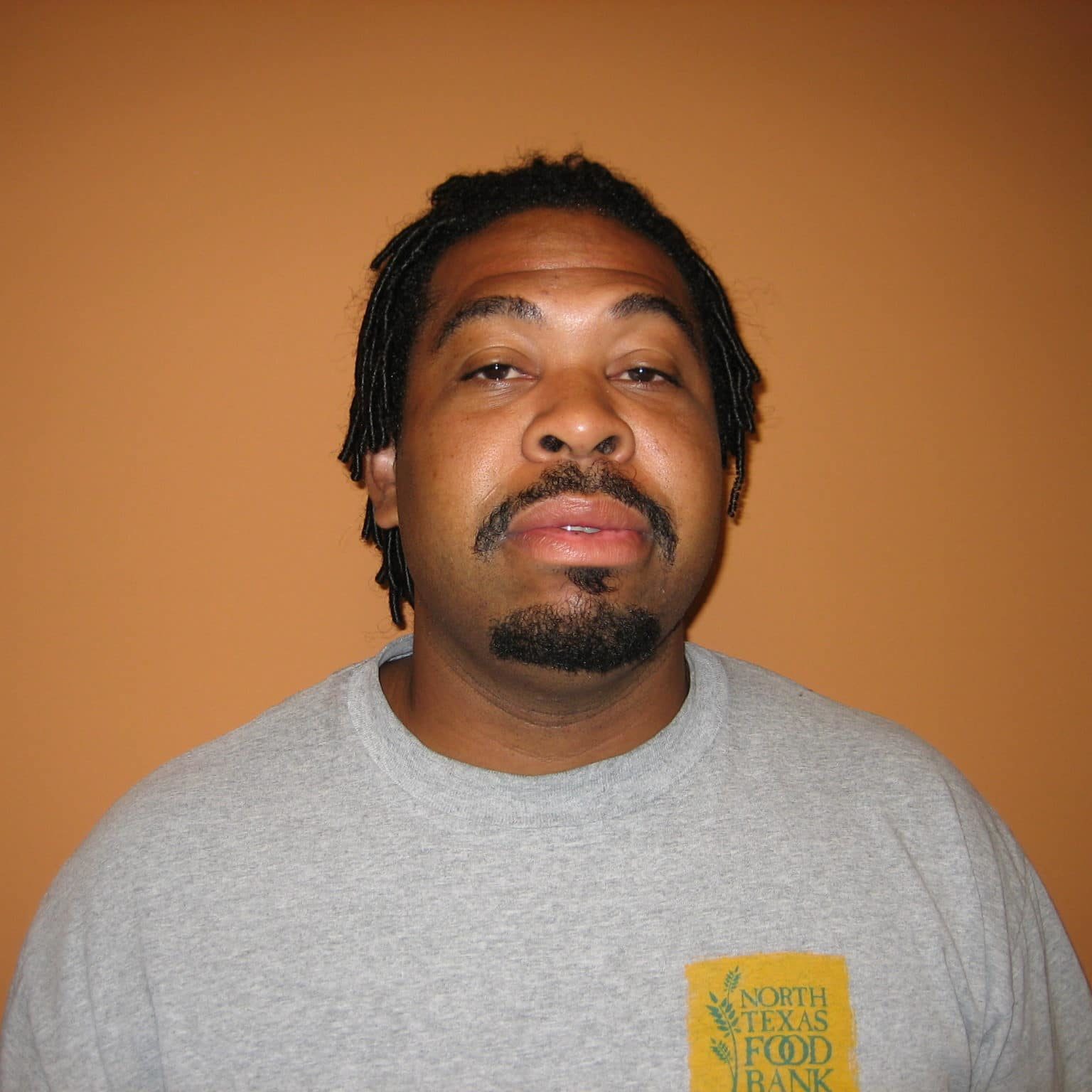 Joe Crawford Receiving Joe Crawford in a grey NTFB t-shirt in front of an orange background