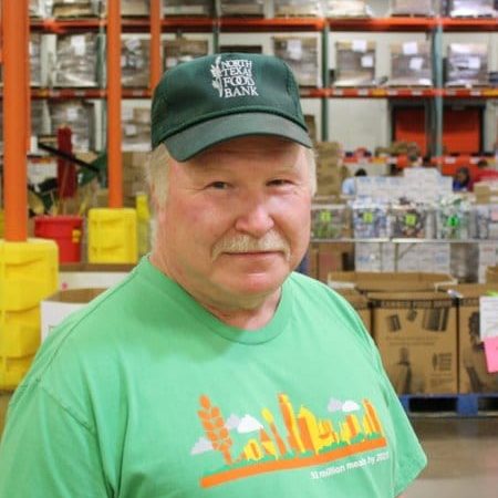 Mike Snider Older white man with white mustache in a green t-shirt and North Texas Food Bank baseball cap