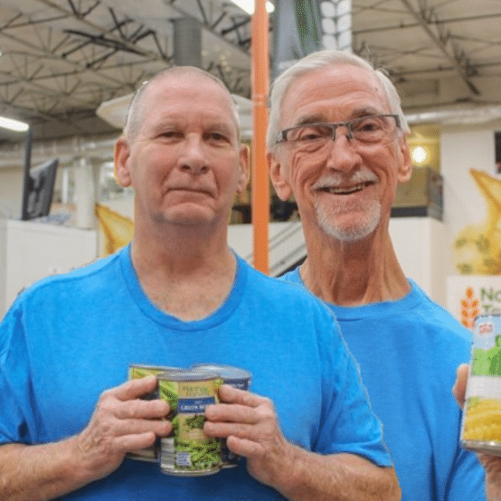 David and Jack Arrington Two older white men in blue shirts holding canned goods